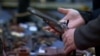 A potential gun buy holds an antique guy.