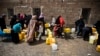 File - Amid an acute water shortage, women and children wait to fill buckets from a public tap in Sana'a, Yemen, May 2015.