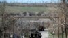 A damaged armed vehicle of pro-Russian rebels stands between the positions of pro-Russian rebels and Ukrainian army in Shyrokyne village, eastern Ukraine, April 10, 2015.