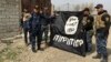 Iraq's federal police forces celebrate as they hold a flag of the Islamic State group they captured after regaining control of Gawsaq neighborhood in the western side of Mosul, Iraq, Feb. 27. 2017.