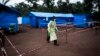 FILE - A health worker walks at an Ebola quarantine unit, June 13, 2017 in Muma, DRC, after a case of Ebola was confirmed in the village.