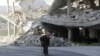 An elderly man walks past a damaged building in the rebel-controlled area of Maaret al-Numan town in Idlib province, Syria, Dec. 21, 2015. 