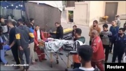 Timu ya Shirika la Mwezi Mwekundu la Palestina likiwafikisha waliouawa katika hospitali ya Al-Awda, huko Jabalia, Ukanda wa Gaza.