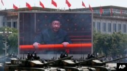 រូប​របស់​ប្រធានាធិបតី​ចិន​ Xi Jinping ត្រូវ​បាន​គេ​ដាក់​បង្ហាញ​នៅ​លើ​ផ្ទាំង​ដ៏​ធំ​មួយ​ ខណៈ​ដែល​រថក្រោះ​ប្រភេទ ៩៩A២ របស់​ចិន​រត់​លើ​ផ្លូវ​ ក្នុង​ក្បួន​យោធា​ក្នុង​ក្រុង​ប៉េកាំង កាលពី​ថ្ងៃទី៣ ខែកញ្ញា ឆ្នាំ២០១៥ ដែល​ជា​ក្បួន​ដើម្បី​អបអរ​សាទរ​ខួប​ទី៧០​ឆ្នាំ​នៃ​ការ​សុំ​ចុះ​ចាញ់​របស់​ជប៉ុន​ក្នុង​សង្រ្គាម​លោក​លើក​ទី២។ 