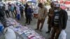 Ethiopians check newspapers and magazines reporting on the current military confrontation in Ethiopia's Tigray region, at a news stand on a street in the capital Addis Ababa, Nov. 7, 2020.
