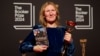 Samantha Harvey poses with the trophy and her book "Orbital" after winning the Booker Prize award 2024, in London, Nov. 12, 2024. 