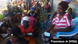 Deslocados, vítimas, da violência armada em Cabo Delgado aguardam na rua com as senhas para adquirir os seus produtos através da ajuda do em Pemba.