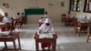 Siswa yang mengenakan masker duduk terpisah saat uji coba kelas dengan protokol COVID-19 di sebuah sekolah dasar di Jakarta, Jumat, 4 Juni 2021. (Foto: AP)