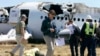 U.S. National Transportation Safety Board (NTSB) investigators stand at the scene of the Asiana Airlines Flight 214 crash site at San Francisco International Airport in San Francisco, July 7, 2013. (NTSB) 