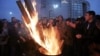 Cheering fans of the Besiktas soccer team gather around a fire outside a courthouse as a trial of dozens of football fans proceeds inside in Istanbul, Dec. 16, 2014.