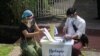 Officers from Union Election Commission arrange ballots for an early voting for upcoming Nov. 8 general election outside a residence on the outskirts of Yangon, Myanmar, Oct. 29, 2020.