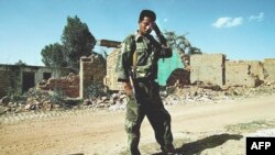 Mwanajeshi wa Eritrea akiwa mbele ya majengo yaliyo haribiwa na mapigano