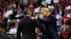 President Donald Trump welcomes Mississippi Lt. Gov. Tate Reeves, left, to the stage at a rally at BancorpSouth Arena in Tupelo, Miss., Nov. 1, 2019.