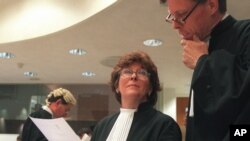 Prosecutor, Justice Louise Arbour, centre, talks to Mark Harmon, right, Senior Trial Attorney, shortly before the beginning of the hearing at the International Criminal Tribunal for former Jugoslavia in The Hague, file photo.