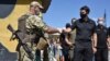 FILE - Ukraine's parliament speaker Dmytro Razumkov, right, greets a soldier at a checkpoint in Mayorsk, Donetsk region, Ukraine, July 29, 2020. Ukrainian and rebel forces in eastern Ukraine launched a comprehensive cease-fire two days earlier.