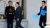 French President Francois Hollande, center, and Prime Minister Manuel Valls, right, walk through the lobby of the Elysee Palace after the weekly cabinet meeting, in Paris, Nov. 18, 2015. 