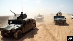 Des véhicules de l'armée yéménite prennent position lors de combats contre Al-Qaïda dans la province de Shabwa, au Yémen, le 8 mai 2014
