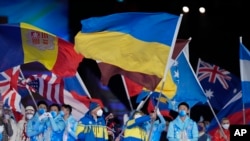 FILE - Vitalii Lukianenko carries the flag of Ukraine during the closing ceremony at the 2022 Winter Paralympics, March 13, 2022, in Beijing.