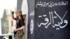 FILE - A militant Islamist fighter uses a mobile to film his fellow fighters taking part in a military parade along the streets of Syria's northern Raqqa province.