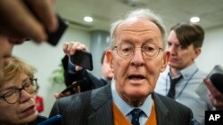 FILE - Sen. Lamar Alexander, R-Tenn., speaks to reporters as he arrives at the Capitol in Washington, Monday, Jan. 27, 2020, during the impeachment trial of President Donald Trump. 