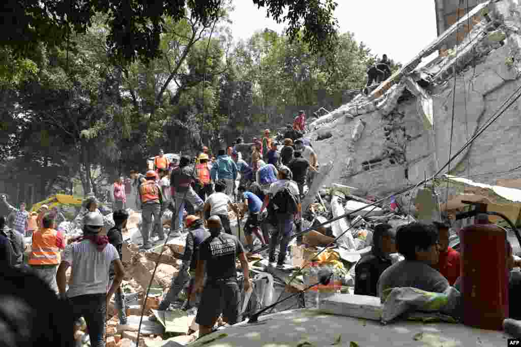 Pessoas removem escombros de um prédio que caiu, procurando por vítimas do tremor de terra na Cidade do México, 19 de Setembro, 2017.