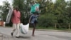 Burundians carry their belongings in Bujumbura, Burundi, Nov. 7, 2015. Carrying their prized possessions, scores of people have fled Burundi’s capital before a security crackdown.