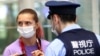La sprinteuse biélorusse Krystsina Tsimanouskaya discute avec des policiers à l'aéroport international de Haneda à Tokyo, au Japon, le 1er août 2021.