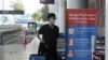 FILE - A tourist wearing a face mask enters an area of thermo scan at the quiet Phnom Penh International Airport in Phnom Penh, Cambodia, Friday, April 3, 2020. 
