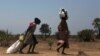 FILE - Women carry food at a food distribution site in Nyal, Unity State, Sudan.