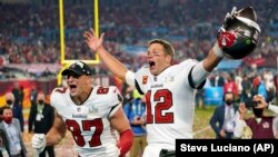 រូបឯកសារ៖ កីឡាករ Rob Gronkowski (ឆ្វេង) និងកីឡាករ Tom Brady នៃក្រុម Tampa Bay Buccaneers អបអរក្រោយការប្រកួត NFL Super Bowl 55 ទល់នឹងក្រុម Kansas City Chiefs នៅទីក្រុង Tampa រដ្ឋ Florida កាលពីថ្ងៃទី៧ ខែកុម្ភៈ ឆ្នាំ២០២១។