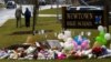 A student is consoled after he placed flowers on a memorial at the entrance to Newtown High School in Newtown, Connecticut December 18, 2012. 