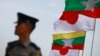 A police officer stands on guard near national flags of Myanmar and Japan during the commencement ceremony of the Thilawa Special Economic Zone (SEZ) project in the Japanese Special Economic Zone at Thilawa outside Yangon November 30, 2013. The first pha