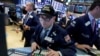 FILE - A trader wears a "Dow 22,000" hat as he works at his post on the floor of the New York Stock Exchange, Wednesday, Aug. 2, 2017. 