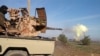 In this image posted on a militant social media account by the Al-Baraka division of the Islamic State group, Feb. 24, 2015, a fighter fires a heavy weapon mounted on the back of a pickup truck in Tal Tamr, Syria.
