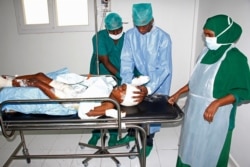 FILE - Medical workers help a child, who was injured in a mortar shell attack, at Medina hospital during Somali Independence day ceremony in Mogadishu, Somalia, July, 1, 2018.