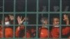 Cambodian prisoners on a prisoner truck arrive at the Phnom Penh Municipal Court in Phnom Penh, Cambodia, Wednesday, Nov. 17, 2021. (AP Photo/Heng Sinith)