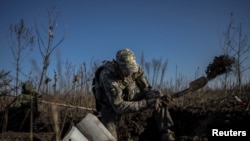 Tentara Ukraina pencari ranjau tampak menggali roket di tengah serangan Rusia di Kherson, Ukraina, pada 9 November 2023. (Foto: Reuters/Viacheslav Ratynskyi)