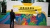 A man looks at a banner outside a polling station during the Legislative Council election in Hong Kong's Hung Hom area, Dec. 19, 2021. 
