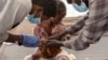 FILE - A Tigray woman who fled the conflict in Ethiopia's Tigray region holds her malnourished and severely dehydrated baby as nurses tend to him at a clinic in a Sudanese refugee camp on Dec. 5, 2020. Tigrayan authorities warn that the region faces a looming famine in 2024.