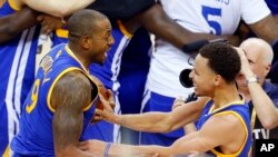 Stephen Curry ( 30 ) , à droite, et Andre Iguodala ( 9 ) célèbrent après avoir remporté le match 6 de la finale de la NBA de basket-ball de Cleveland , le mardi 16 Juin , 2015. Les Warriors ont battu les Cavaliers 105-97 pour gagner le best-of -sept ...