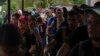 Migrantes que atravesaron el Tapón del Darién se alinean para inspecciones de sus pertenencias en Lajas Blancas, Panamá, el 26 de septiembre de 2024. Según el gobierno panameño, más de 196.000 venezolanos han cruzado esa zona boscosa de forma ilegal. (ARCHIVO: AP)