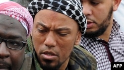 This photo taken on May 5, 2012, shows former German rapper Denis Cuspert, center, among salafi in Bonn, Germany.