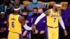LeBron James and Carmelo Anthony of the Los Angeles Lakers touch hands in a break of action against the Golden State Warriors during their NBA season opener in Los Angeles, California on October 19, 2021. (Photo by Frederic J. BROWN / AFP)