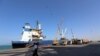 FILE - A coastguard walks past a ship docked at the Red Sea port of Hodeida, Yemen, Jan. 5, 2019. 