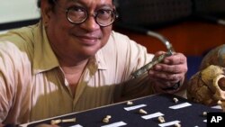 Filipino archeologist Armand Salvador Mijares shows bones and teeth they recovered from Callao Cave belonging to a new specie they called Homo luzonensis during a press conference in metropolitan Manila, Philippines on Thursday, April 11, 2019. (AP Photo/
