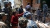 Nepalese resident Sangita Mahat, center, directs police as they retrieve the body of her relative Prasamsah, 14, during rescue efforts in Balaju in Kathmandu, April 27, 2015. 