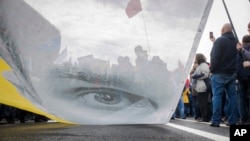 Protesters hold a poster with the image of political prisoner Oleg Sentsov during an opposition rally organized by 'Free Russia' in Moscow, Russia, Sunday, June 10, 2018. 