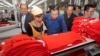 FILE: Prime Minister Hun Sen, center, leans over a garment worker during a visit to a factory outside of Phnom Penh, Cambodia, Aug. 30, 2017.