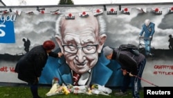 People view a mural of late record-breaking centenarian Captain Tom Moore, who died on Tuesday, in Two Gates, Tamworth, Britain, Feb. 3, 2021.