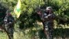 FILE - A Hezbollah fighter holds an Iranian-made anti-aircraft missile, right, as he takes his position with his comrade between orange trees, at the coastal border town of Naqoura, south Lebanon, April 20, 2017.
